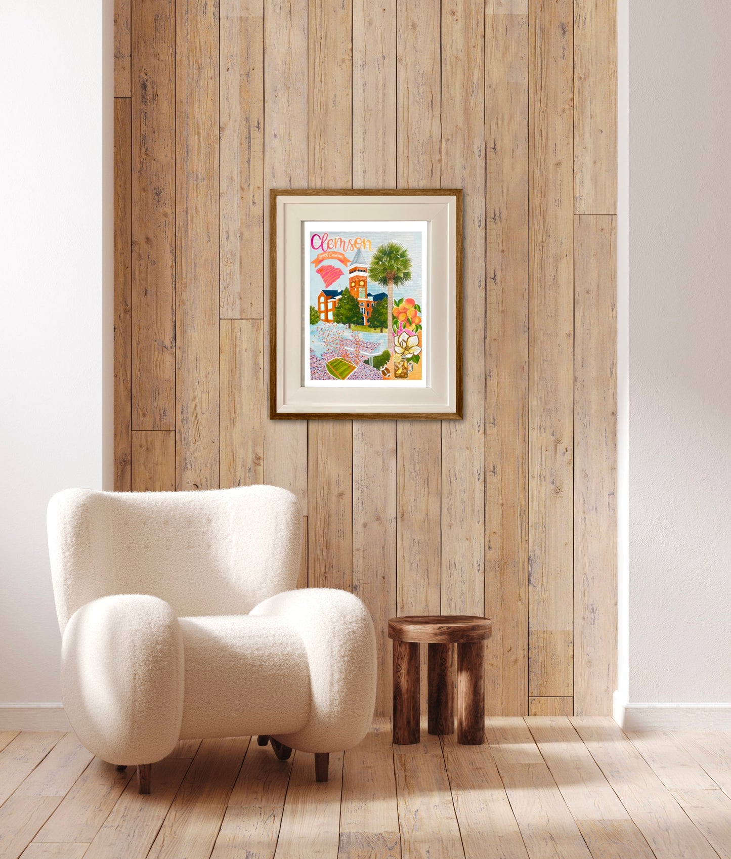 A colorful art print rests in a white frame featuring details unique to Clemson South Carolina. There is a palmetto, magnolia, a jar or sweet tea, and a football stadium. This frame is cream colored white with. 