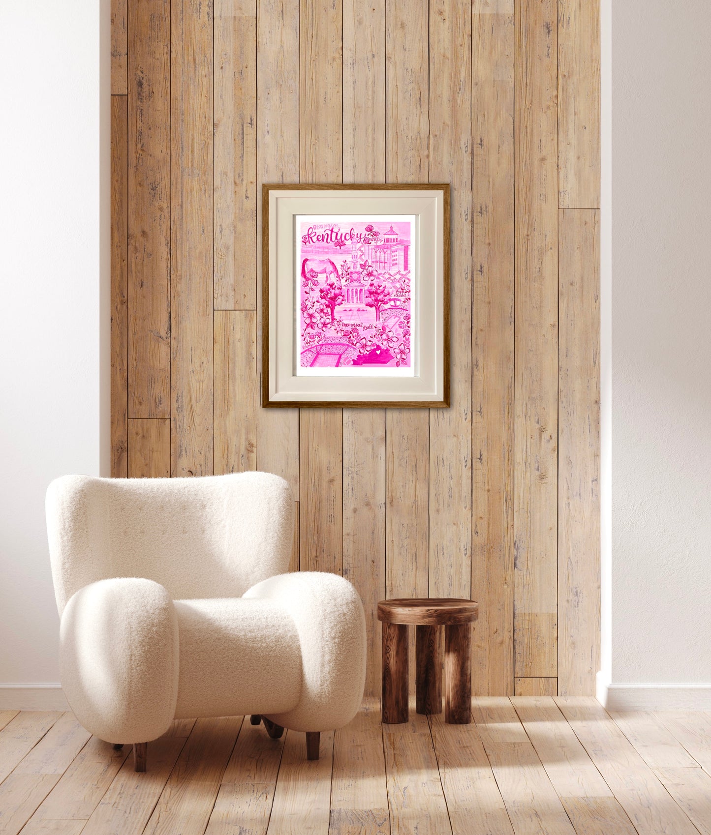 This a pink toile art print title with hot pink calligraphy hand lettering. This artwork features fun landmarks unique to Lexington, Kentucky! Art print is in a cream mat frame with wood. The print rests on a beach wood paneled wall.