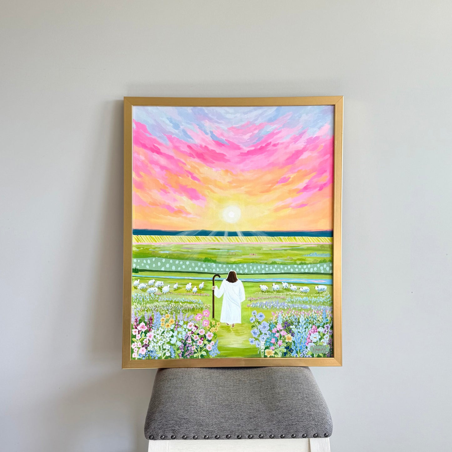Framed painting of the Savior walking on a bright path surrounded by a colorful field of flowers and rolling hills in the distance