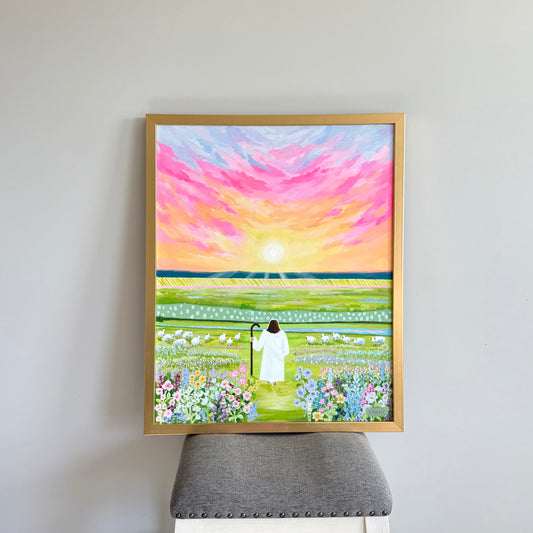 Framed painting of the Savior walking on a bright path surrounded by a colorful field of flowers and rolling hills in the distance